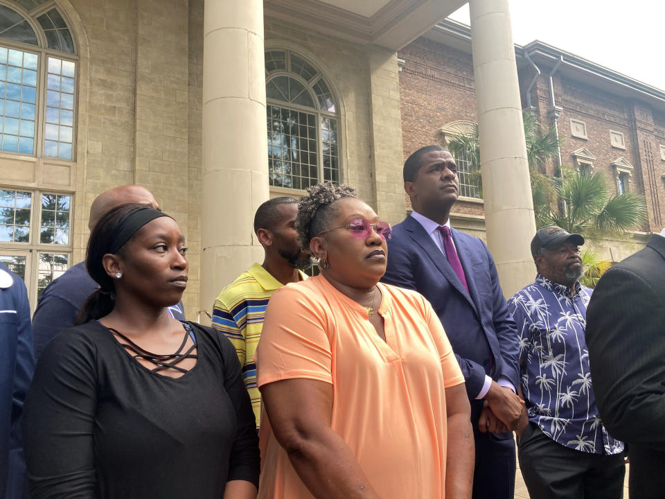 Latonya James, left, her mother Betty James, center, and their attorney Bakari Sellers, second from right, stand during a news conference Monday, Aug. 22, 2022, in Woodbine, Ga. to announce a federal lawsuit against the Camden County sheriff and others. Betty James' daughter, Latoya James, was killed by gunfire after Camden County deputies executed a drug warrant at her cousin's home on May 4, 2021. The lawsuit says deputies violated the slain woman's civil rights by failing to give the home's occupants time to answer the door. (AP Photo/Russ Bynum)