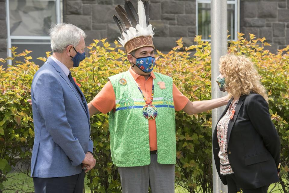 Higgs, left, and New Brunswick Aboriginal Affairs Minister Arlene Dunn, right, speak with Chief Alan Polchies Jr. of St. Mary’s First Nation after raising flags as part of National Indigenous Peoples Day in Fredericton, N.B., in June 2021. THE CANADIAN PRESS/Stephen MacGillivray