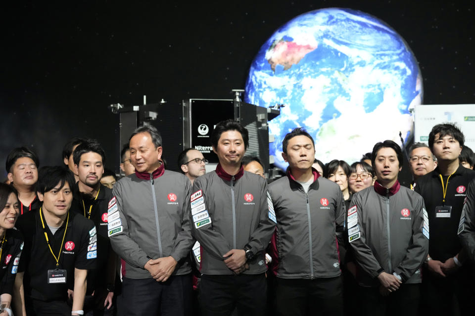 Takeshi Hakamada, center, founder and CEO of ispace, and his team staff gather for photo session after livestream of HAKUTO-R private lunar exploration program on screen at the lunar landing event Wednesday, April 26, 2023, at Miraikan, the National Museum of Emerging Science and Innovation, in Tokyo. Tokyo's ispace tried to land its own spacecraft on the moon early on Wednesday, but its fate was unknown as flight controllers lost contact with it moments before the planned touchdown. (AP Photo/Eugene Hoshiko)