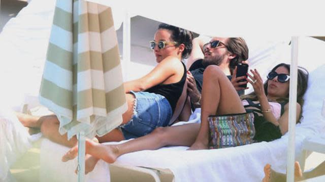 Scott Disick seems to be having a great time on vacation in Monaco, with no kids or Kourtney Kardashian in sight. The reality star was spotted getting touchy-feely with a mystery woman on the beaches of Monte Carlo, snuggling up on a lounge chair together and even feeding each other! Splash News <strong>NEWS: Kourtney Kardashian Welcomes Third Child with Scott Disick</strong> While Disick is not married to Kardashian, with whom he welcomed his third child in December 2014, the pair have not publicly announced any change in their relationship. Some outlets are speculating that the woman is no mystery to Disick, rather someone from his past: ex-girlfriend Chloe Bartoli. Bartoli and her twin sister Marie-Lou are Hollywood fashionistas who have styled Poppy Delevigne, Miranda Kerr, and Selena Gomez, among others. <strong>NEWS: Scott Disick Hosts Vegas Party, Says He Plans to Go Back to Rehab </strong> Disick is not the twins’ only link to the Kardashian family, however. Another of the Bartolis’ clients, Chrissy Teigen, is close with Kim Kardashian and Kanye West through her husband John Legend. The couples have been on at least one double date, and Teigen and Legend even attended Kimye’s Italian wedding back in May 2014. Seems like Hollywood’s a small world, after all! <strong>EXCLUSIVE: Is Scott Disick Really Being Paid To Go to Rehab?</strong>