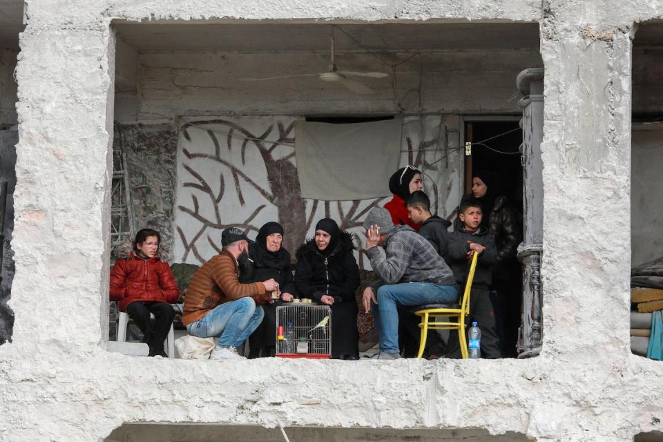 Syrians gather in Aleppo, in a building damaged by the February 2023 earthquake. <a href="https://www.gettyimages.com/detail/news-photo/ali-al-bash-and-his-mother-amina-raslan-drink-coffee-at-news-photo/1247370119?adppopup=true" rel="nofollow noopener" target="_blank" data-ylk="slk:Louai Beshara/AFP via Getty Images;elm:context_link;itc:0;sec:content-canvas" class="link ">Louai Beshara/AFP via Getty Images</a>