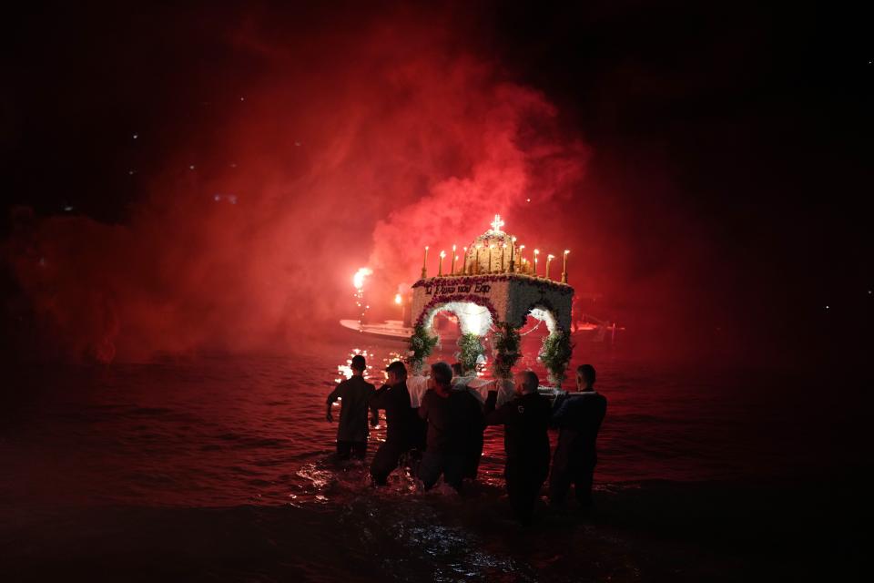 Men carry into the sea the "Epitaph", the procession of Jesus' funeral bier in the seaside town of Tolo, about 150 kilometres (94 miles) southwest of Athens, Greece, Friday, April 14, 2023. About 300 million Orthodox Christians around the world will celebrate Easter on Sunday, April 16, the most important religious holiday in the Orthodox Christian calendar. (AP Photo/Thanassis Stavrakis)