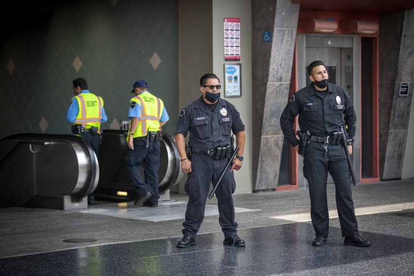 HOLLYWOOD, CA - JUNE 25: LAPD officers E. Rosales, center, and D. Castro, right, and Metro contract security officers, left, patrol the Metro Red Line Hollywood/Highland Metro Station Thursday, June 25, 2020 in Hollywood, CA. The Metro Board of Directors held a meeting Thursday where the agenda included the consideration of appointing a committee to develop plans for replacing armed transit safety officers with ``smarter and more effective methods of providing public safety.'' Metro security is staffed by multiple agencies, including the L.A. County Sheriff's Department and L.A. and Long Beach police departments, transit security guards and contract security workers. (Allen J. Schaben / Los Angeles Times)