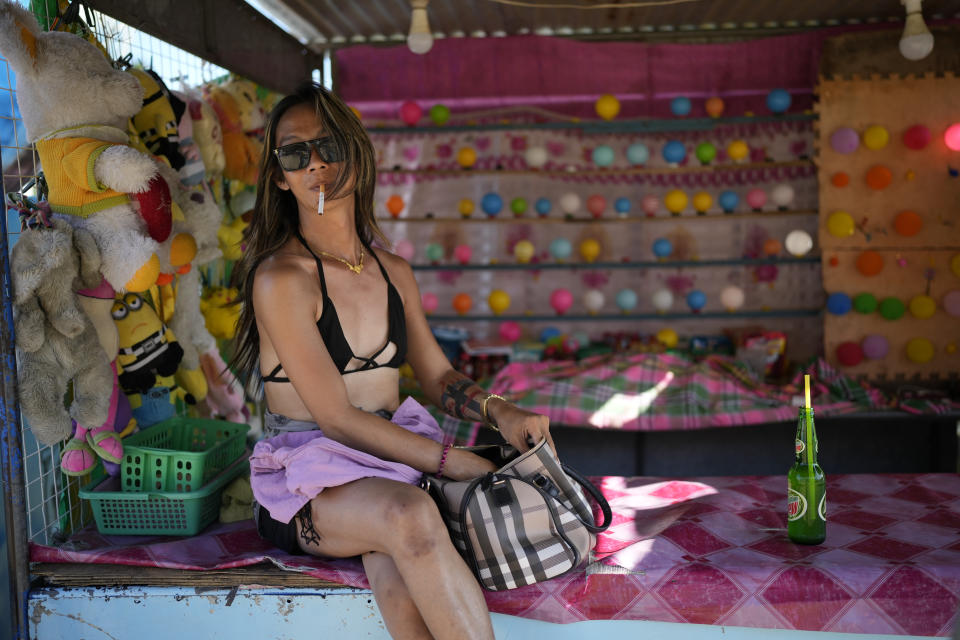 A carnival worker sits in front of a games stall in front of the town municipal hall in Santa Ana, Cagayan province, northern Philippines, Tuesday, May 7, 2024. The United States and the Philippines, which are longtime treaty allies, have identified the far-flung coastal town of Santa Ana in the northeastern tip of the Philippine mainland as one of nine mostly rural areas where rotating batches of American forces could encamp indefinitely and store their weapons and equipment within local military bases under the Enhanced Defense Cooperation Agreement, or EDCA. (AP Photo/Aaron Favila)