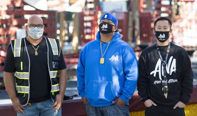 OAKLAND, CA - FEBRUARY 28, 2021 - Members of Asians With Attitudes (AWA) Sakhone Lasaphangthong (L), Jimmy Bounphengsy (C) and John Le (R) pause for a photo before beginning a patrol in the chinatown district of Oakland, California on February 28, 2021. (Josh Edelson/for the Times)