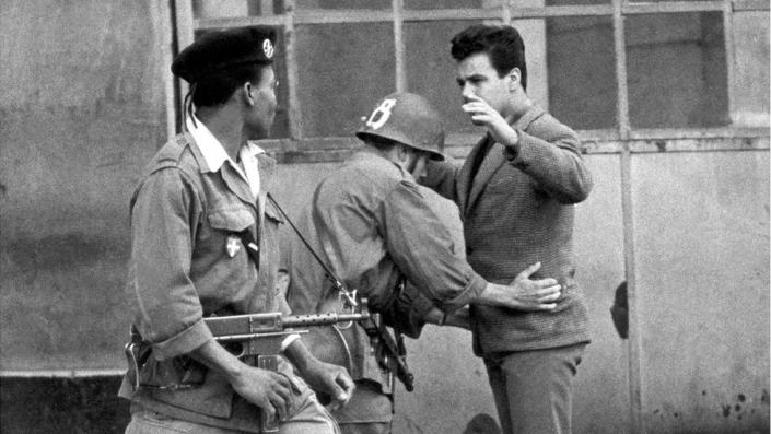 French troops frisk an Algerian during the independence struggle