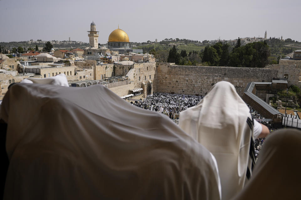 Covered in prayer shawls, Jewish men of the Cohanim Priestly caste participate in a blessing during the holiday of Passover, overlooking the Western Wall, the holiest site where Jews can pray, with the golden Dome of the Rock in the background, in Jerusalem's Old City, Sunday, April 9, 2023. The Cohanim, believed to be descendants of priests who served God in the Jewish Temple before it was destroyed, perform a blessing ceremony of the Jewish people three times a year during the festivals of Passover, Shavuot and Sukkot. (AP Photo/Ohad Zwigenberg)