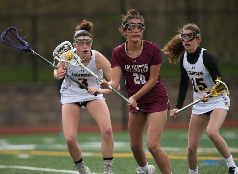 Arlington's Amanda Mauro looks to pass the ball as she's covered by Lourdes', from left, Claire Bottjer and Ella Jentsch during Tuesday's game on May 3, 2022. 