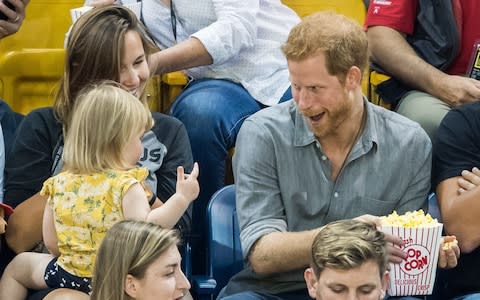 Prince Harry pulls his popcorn away from Emily - Credit: Samir Hussein/WireImage