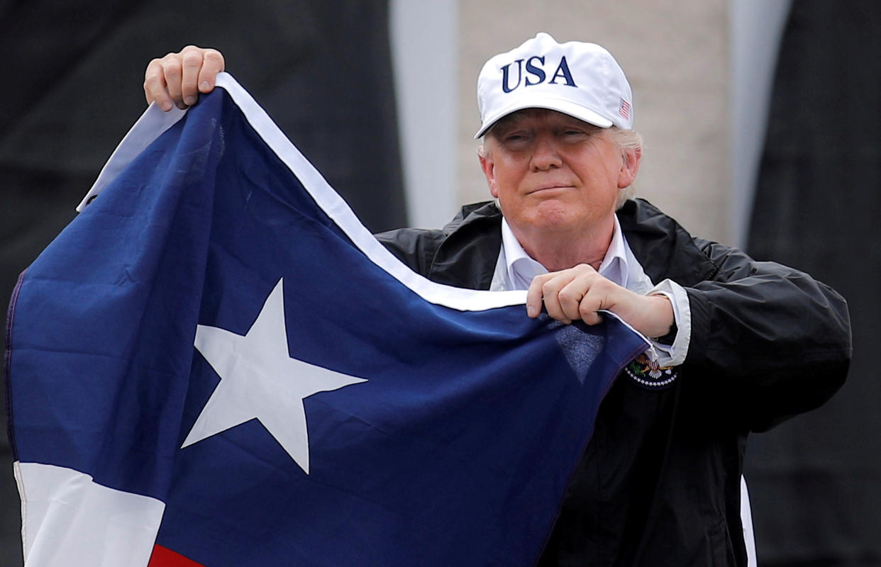 President Donald Trump holds the Texas flag after receiving a briefing on Tropical Storm Harvey relief efforts in Corpus Christi, Texas, on Aug.&nbsp;29, 2017. (Photo: Carlos Barria/Reuters)