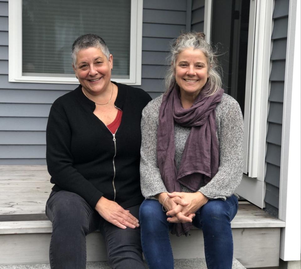 Tanya Alsberg, left, and Jennifer Armstrong are all smiles on the front steps of their new home, which the Kennebunkport Heritage Housing Trust built and sold to them at an affordable price earlier this year.