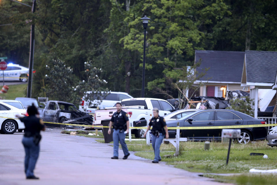 Hattiesburg police surround a burned automobile and a damaged home after a small plane crashed late Tuesday night in Hattiesburg, Miss., Wednesday May 5, 2021. Emergency officials in Mississippi say multiple people were killed when the small plane crashed into a home. (AP Photo/Chuck Cook)