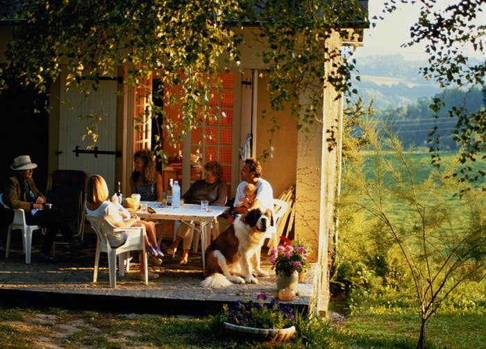 A family eating a meal outside in the country.