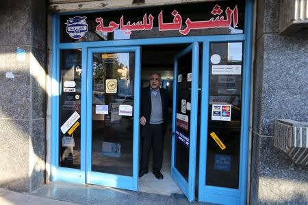 Palestinian travel agent Nabil Shurafa stands at the entrance of his office in Gaza City February 4, 2016. REUTERS/Ibraheem Abu Mustafa