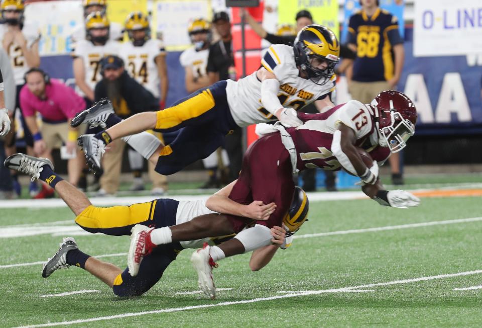 O'Neill's Jordan Thompson (13) gets high and low by General Brown defenders during the state Class C football championships at JMA Wireless Dome in Syracuse Dec. 3, 2022. 