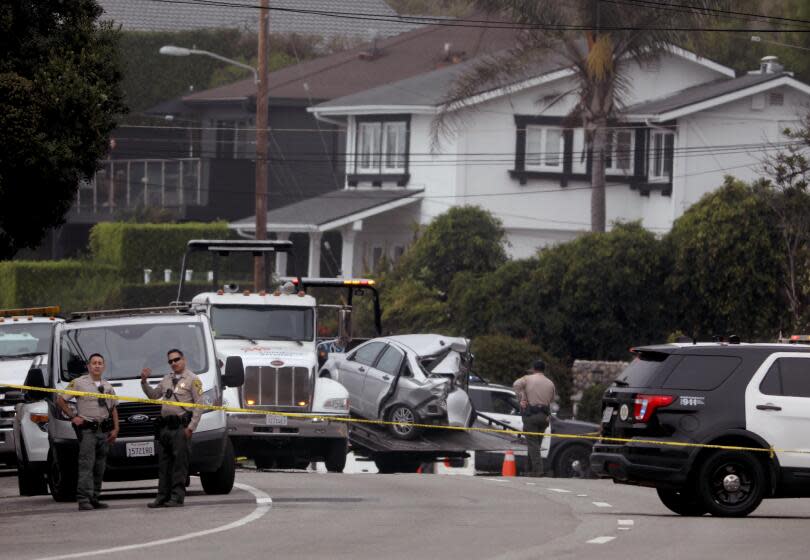 LOS ANGELES, CA - OCTOBER 18, 2023 - Sheriff deputies monitor the scene where four women were killed in a multi-vehicle crash in Malibu on October 18, 2023. A 22-year-old man was arrested after plowing into the pedestrians and parked cars. The crash was reported at 8:30 p.m. Tuesday in the 21600 block of Pacific Coast Highway where they found the victims of the crash, along with the severely damaged vehicles. The crash began when the suspect lost control of his BMW and slammed into multiple parked cars before ricocheting and fatally striking the women, who were standing on the side of the road. (Genaro Molina / Los Angeles Times)