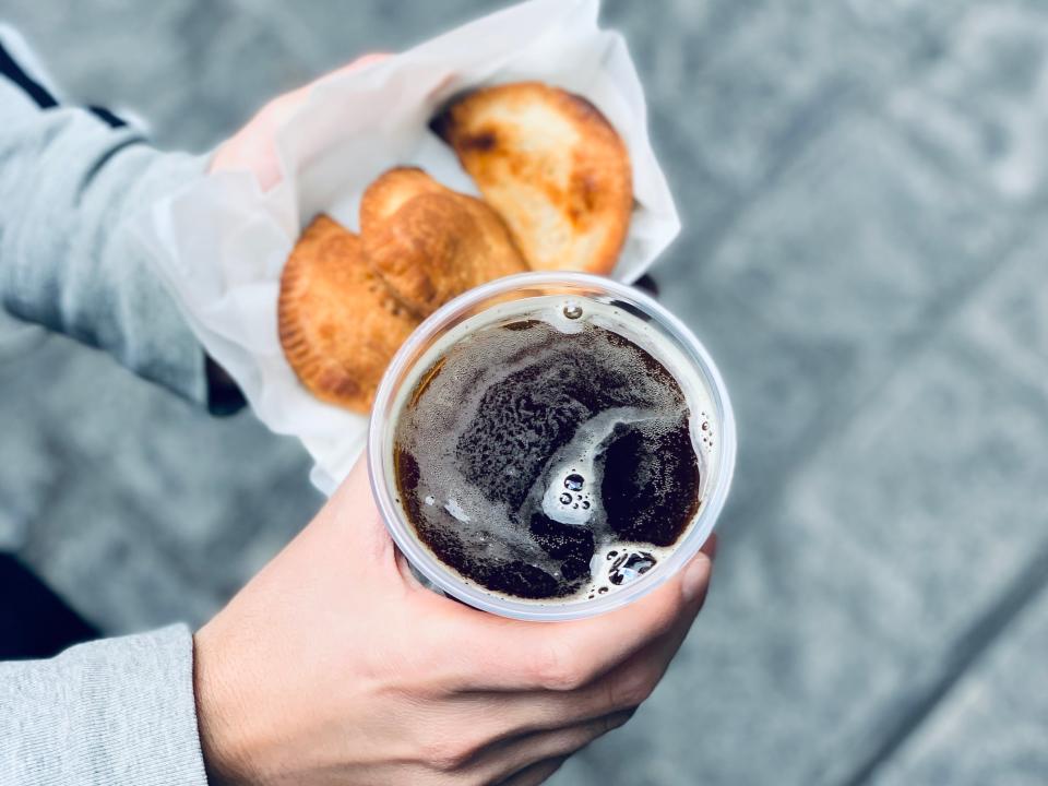 hands holding a pint of dark beer and fried food from the wizarding world of harry potter