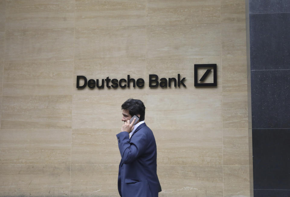 A man walks past the Deutsche Bank sign in London, Monday, July, 8, 2019. Germany's struggling Deutsche Bank says it will cut 18,000 jobs by 2022,  saying it is going “back to our roots” with a radical restructuring plan meant to focus the company on traditional strengths.(AP Photo/Natasha Livingstone)