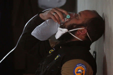 A civil defence member breathes through an oxygen mask, after what rescue workers described as a suspected gas attack in the town of Khan Sheikhoun in rebel-held Idlib, Syria. REUTERS/Ammar Abdullah