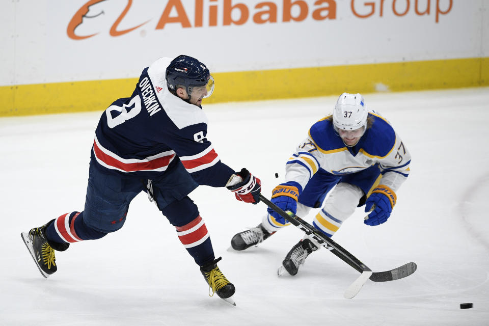 Washington Capitals left wing Alex Ovechkin (8) shoots the puck past Buffalo Sabres center Casey Mittelstadt (37) during the second period of an NHL hockey game Thursday, April 15, 2021, in Washington. (AP Photo/Nick Wass)