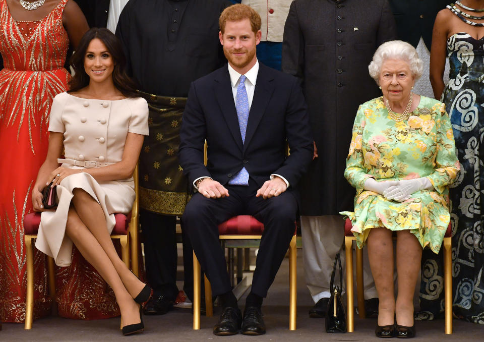 The Duchess of Sussex was criticised for her cross-legged position when posing for a photocall at the Queen’s Young Leaders Awards Ceremony at Buckingham Palace on 26 June [Photo: Getty]