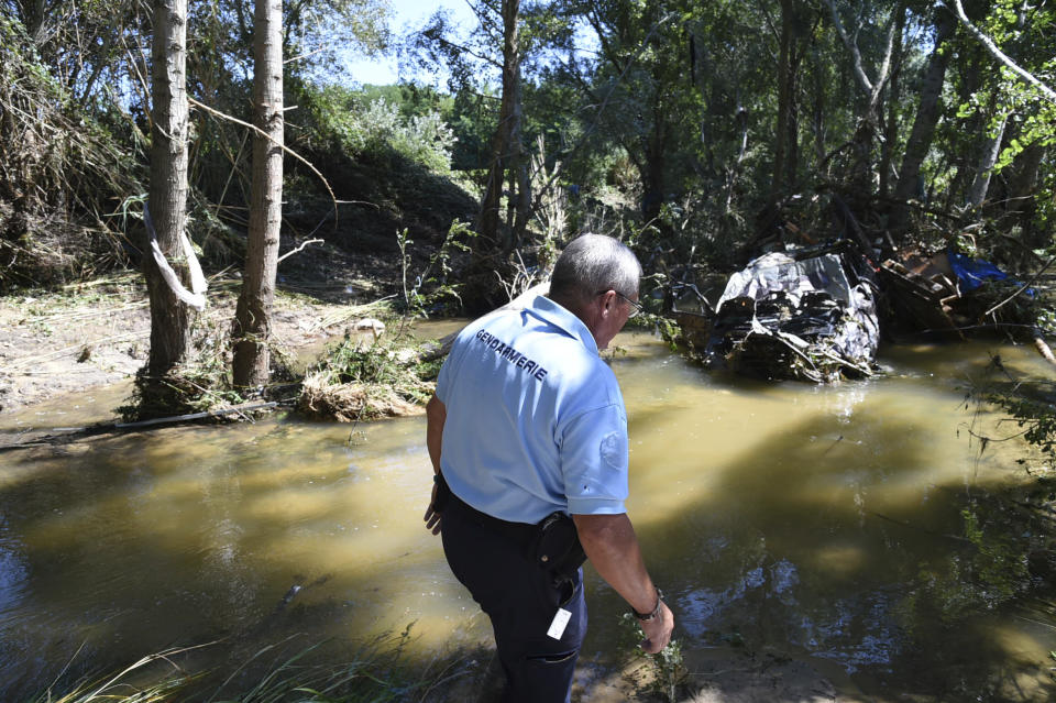 In this photo provided by the French Gendarmerie Nationale, a gendarme walks by the river after floods at Saint-Julien de Peyrolas camping site, in southern France, Friday, Aug. 10, 2018. About 1,600 people have been evacuated due to flash flooding in southern France, most of them from campsites near swollen rivers and streams. (Jose Rocha/French Gendarmerie Nationale via AP)