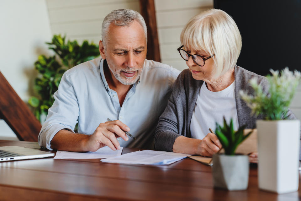 Mature couple with financial documents in home interior. Source: Getty Images