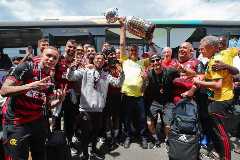 El presidente de Brasil y candidato a la reelección, Jair Bolsonaro, posando con la Copa Libertadores junto a los campeones, los jugadores de Flamengo, en el aeropuerto Galeao de Río de Janeiro