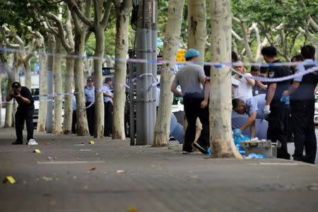 Police officers work at the scene after a man armed with a knife attacked students at the entrance to a primary school, in Xuhui district of Shanghai, China June 28, 2018. REUTERS/Stringer