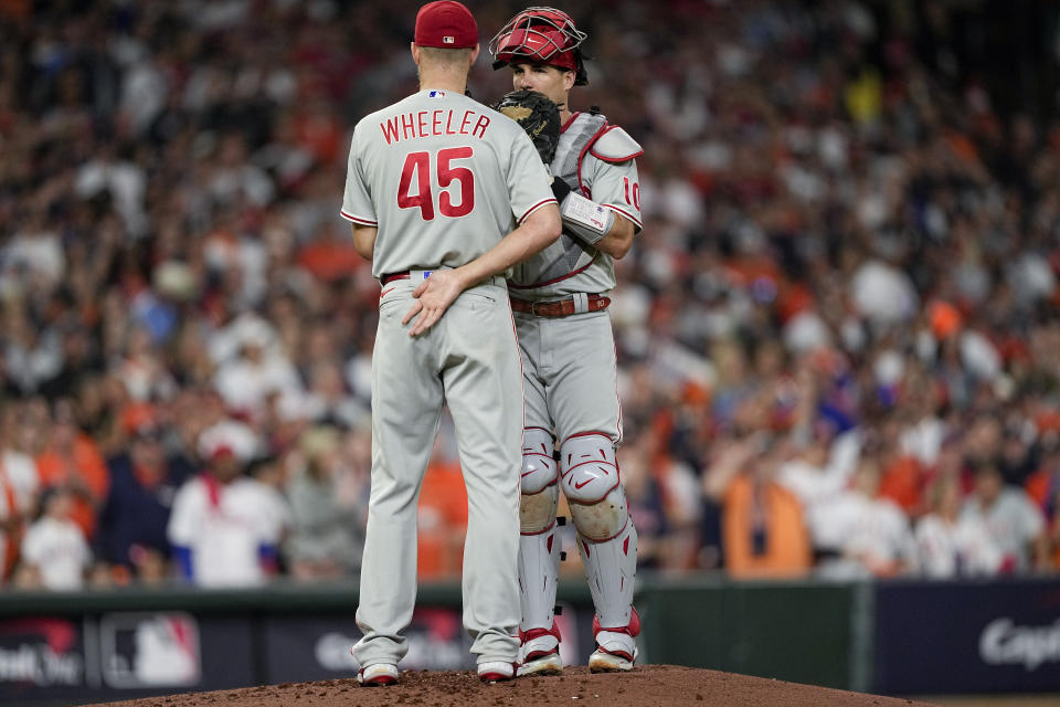 Philadelphia Phillies' Zack Wheeler and J.T. Realmuto speak on the mound during the first inning in Game 2 of baseball's World Series between the Houston Astros and the Philadelphia Phillies on Saturday, Oct. 29, 2022, in Houston. (AP Photo/David J. Phillip)