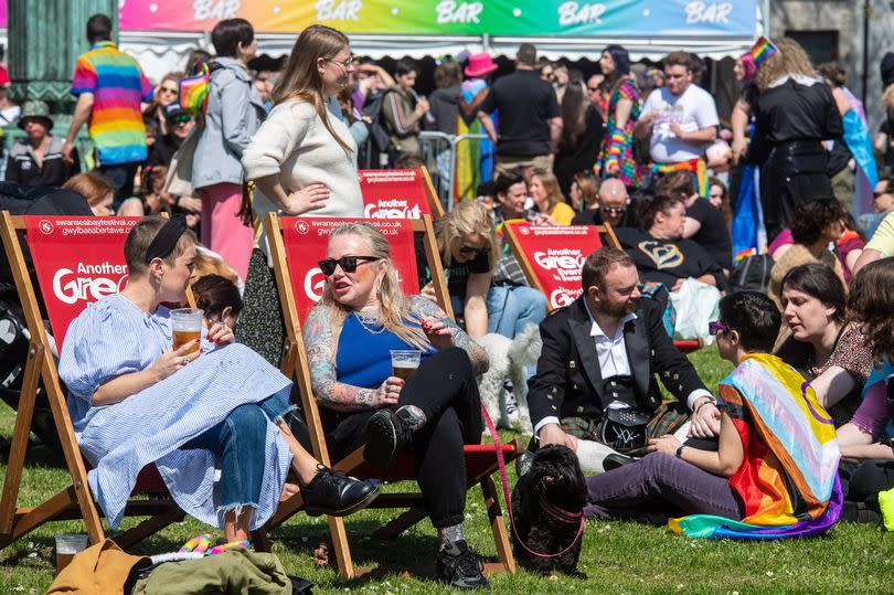 People relaxing in the sunshine at the Swansea Pride festival last year