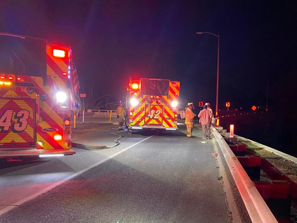 A picture showing medics talking with the driver of the Tesla that crashed.