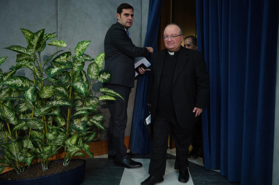 Malta's Archbishop Charles Scicluna, right, is welcomed by Vatican spokesman Alessandro Gisotti as he arrives for a press conference to present the new sex abuse law, at the Vatican's press room, Rome, Thursday, May 9, 2019. Pope Francis issued a groundbreaking law Thursday requiring all Catholic priests and nuns around the world to report clergy sexual abuse and cover-up by their superiors to church authorities, in an important new effort to hold the Catholic hierarchy accountable for failing to protect their flocks. (AP Photo/Andrew Medichini)