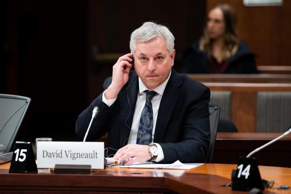 Director of the Canadian Security Intelligence Service (CSIS), David Vigneault, adjusts a translation aid as he waits to appear before a parliamentary committee in Ottawa on Monday, Feb. 6, 2023. 