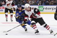 Arizona Coyotes forward Conor Garland (83) controls the puck next to St. Louis Blues center Tyler Bozak (21) during the first period of an NHL hockey game Thursday, Feb. 20, 2020, in St. Louis. (AP Photo/Dilip Vishwanat)
