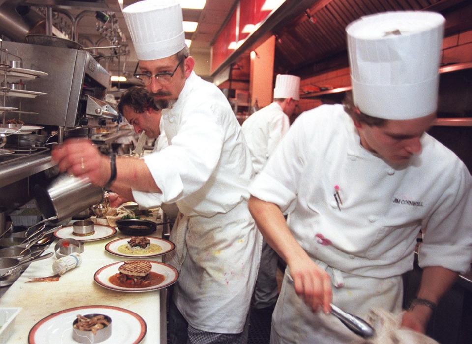 1997: Todd Westermeyer (front left) and Jim Cornwell (right) work the fish station on the cook's line. Behind Westermeyer is Jean Robert de Cavel.