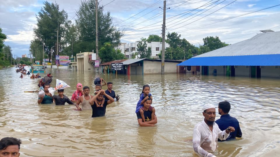 Residents of Feni in Bangladesh walk to higher ground after severe flooding. - CNN/Salman Saeed