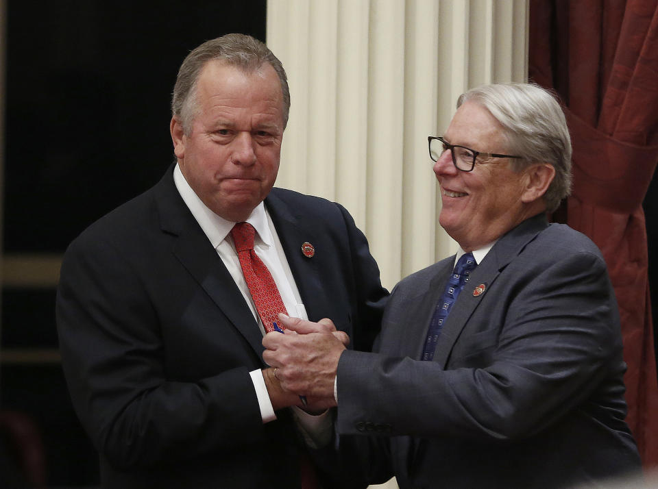 State Sen. Bill Dodd, D-Napa, left, receives congratulations from Sen. Bill Monning, D-Carmel, after the Senate approved a measure Dodd carried to allow utilities to pass cost of the 2017 wildfires on to customers, Friday, Aug. 31, 2018, in Sacramento, Calif. Both houses approved the bill and it was sent it to Gov. Jerry Brown. (AP Photo/Rich Pedroncelli)