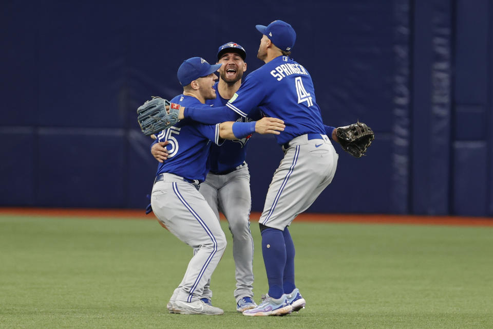 Toronto Blue Jays outfielders George Springer, right, Kevin Kiermaier, center, and Daulton Varsho, left, celebrate after they defeated the Tampa Bay Rays in a baseball game Sunday, Sept. 24, 2023, in St. Petersburg, Fla. (AP Photo/Scott Audette)