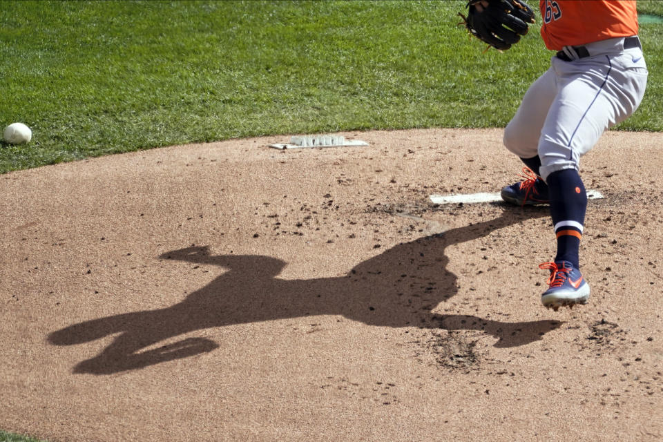 Houston Astros pitcher Jose Urquidy's shadow displays on the mound as he throws against the Minnesota Twins in the first inning of an American League wild-card series baseball game, Wednesday, Sept. 30, 2020, in Minneapolis. (AP Photo/Jim Mone)