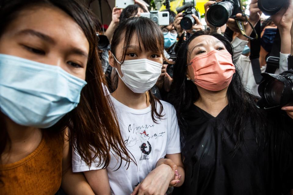 Pro-democracy activist Agnes Chow (C) walks through the media pack after being released from prison in Hong Kong on June 12, 2021, after spending seven months behind bars for her role in a protest outside the police headquarters in 2019. (Photo by ISAAC LAWRENCE / AFP) (Photo by ISAAC LAWRENCE/AFP via Getty Images)