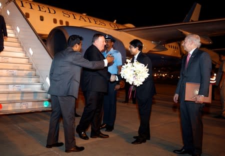 U.S. Secretary of State Mike Pompeo receives flowers from Indian Joint Secretary of the Americas Shri Gourangalal Das upon arrival in New Delhi
