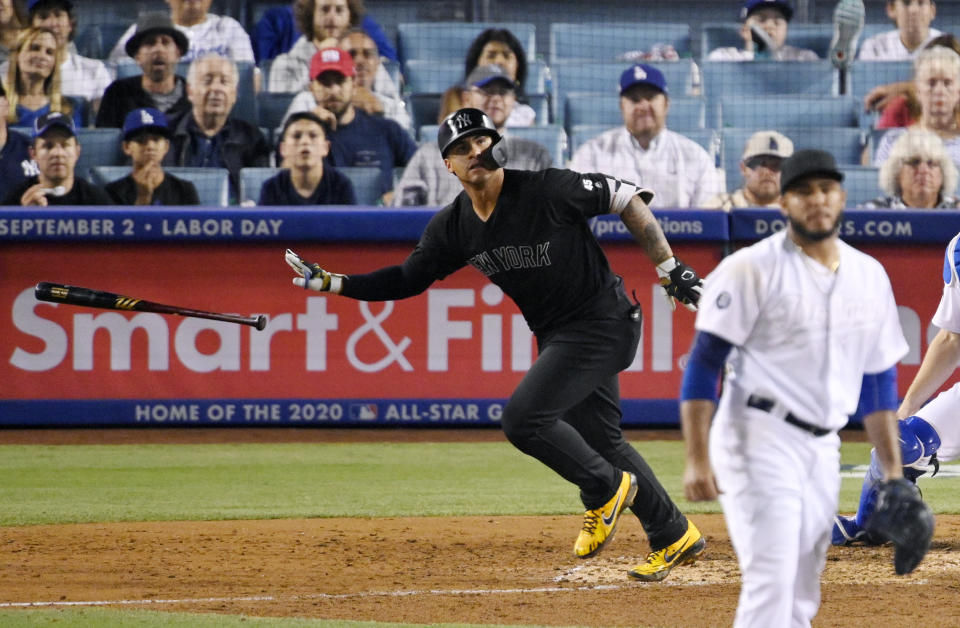 New York Yankees' Gleyber Torres, left, tosses his bat while running to first after hitting a solo home run off Los Angeles Dodgers relief pitcher Yimi Garcia, right, during the sixth inning of a baseball game Friday, Aug. 23, 2019, in Los Angeles. (AP Photo/Mark J. Terrill)
