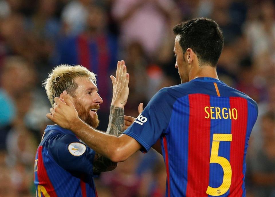 Lionel Messi and Sergio Busquets celebrate a goal against Sevilla in the Spanish Super Cup on Wednesday at the Nou Camp. (Reuters)