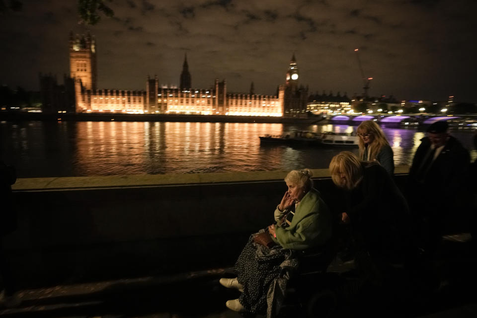 An elderly woman sitting in a wheel chair waits in line to pay tribute to Queen Elizabeth II in London, Thursday, Sept. 15, 2022. The Queen will lie in state in Westminster Hall for four full days before her funeral on Monday Sept. 19. (AP Photo/Andreea Alexandru)