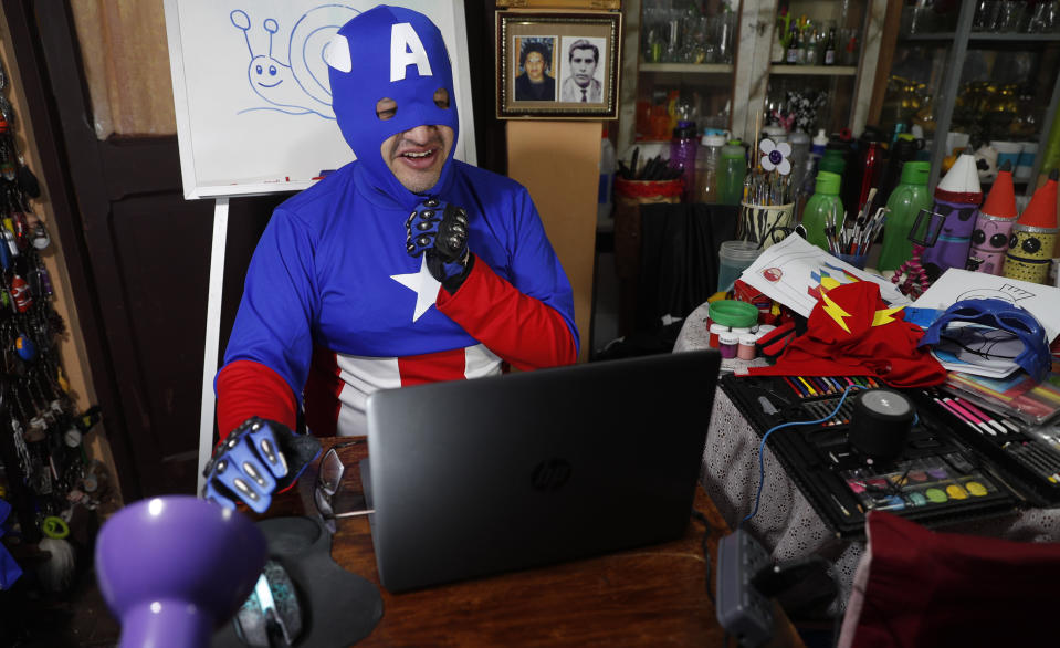 Art teacher Jorge Manolo Villarroel, wearing a Captain America costume, teaches an online class from his home, amid the new coronavirus pandemic in La Paz, Bolivia, Tuesday, June 9, 2020. His classes have become so popular that siblings fight for computer time to learn from this costumed teacher. (AP Photo/Juan Karita)