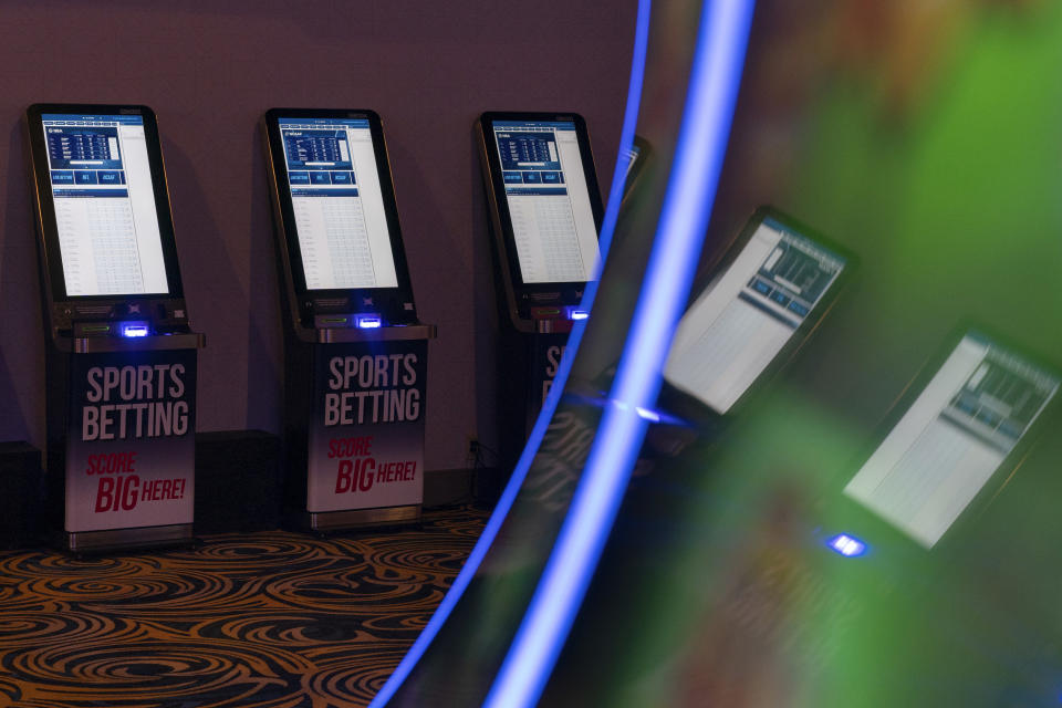 Sports betting kiosks are reflected in an electronic gaming machine at Turfway Park Racing & Gaming, Friday, Dec. 22, 2023, in Florence, Ky. Sports betting has spread rapidly across U.S. states in the past five years. But the odds for further expansion may be fading as state legislatures prepare to return to work in 2024. (AP Photo/Carolyn Kaster)