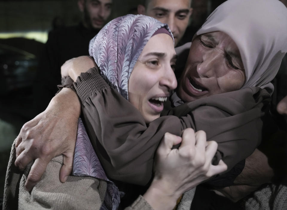 Shuruq Dwayat, left, a Palestinian prisoner released by Israel, is hugged by relatives as she arrives home in the east Jerusalem neighborhood of Sur Bahar, early Sunday Nov. 26, 2023. (AP Photo/Mahmoud Illean)