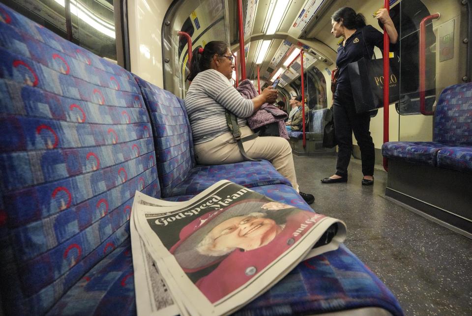 A newspaper with a picture of Queen Elizabeth II lies on a seat in a subway on Monday early morning, Sept. 12, 2022. On morning television, the moment was singularly somber — the departure of the hearse bearing the flag-draped coffin of Queen Elizabeth II. But at the very same hour, as fans in shorts and Ray-Bans streamed into London's Oval stadium for a long-anticipated cricket match, you wouldn't have guessed the country was preparing for the most royal of funerals. (AP Photo/Martin Meissner)