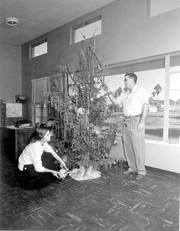 Claude Garland and his secretary decorate a Christmas tree in Leesburg, in 1953.
